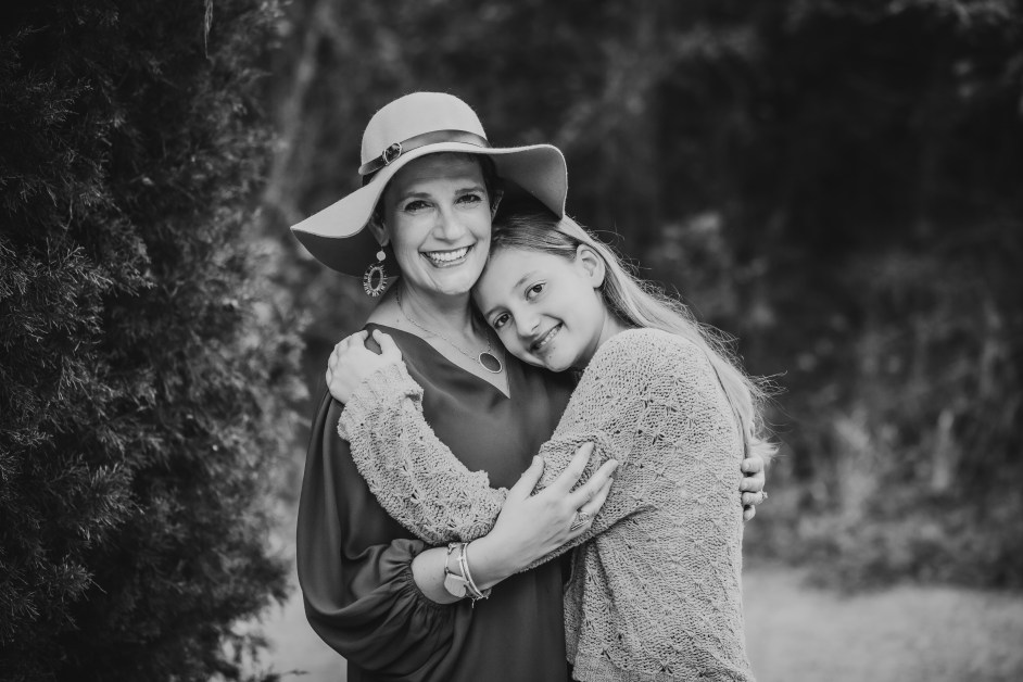 Black and white picture of Mom hugging young teenage daughter.