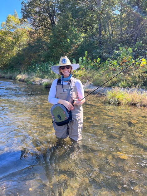 Woman fly fishing in shallow water