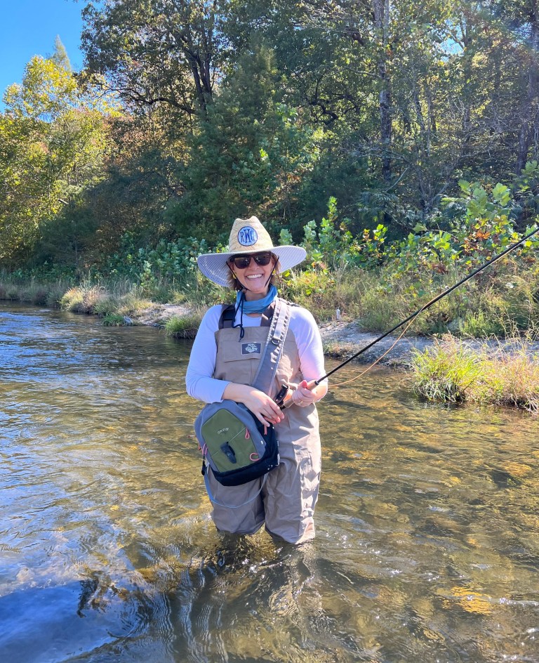 Woman fly fishing in shallow water