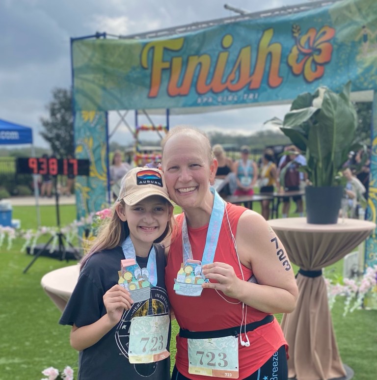 Mom and daughter smiling at race finish line